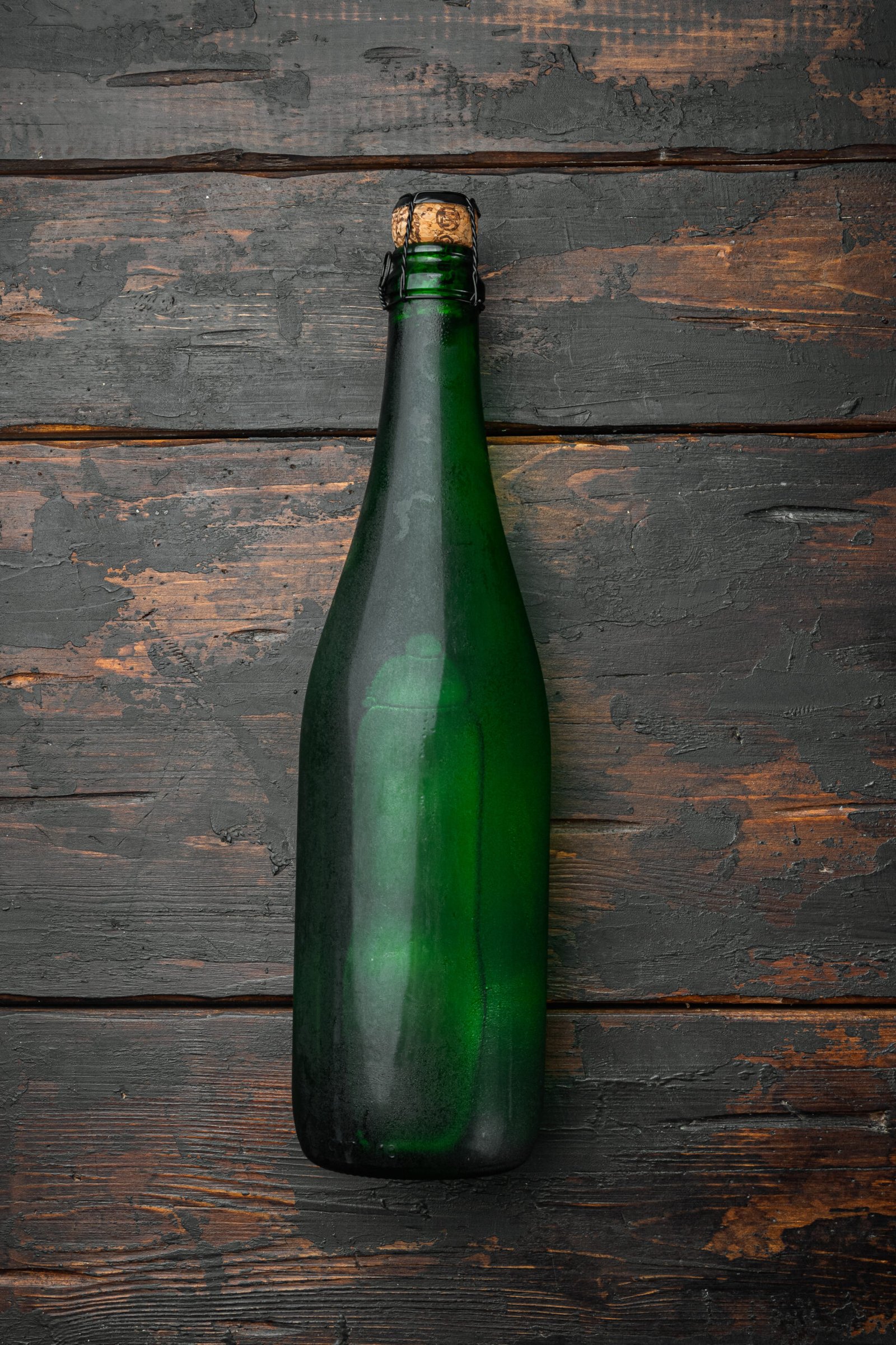 Bottle of sparkling wine, on old dark  wooden table background,
